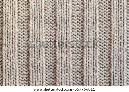 Creamy wool knitted warm clothes for the winter fabric texture background