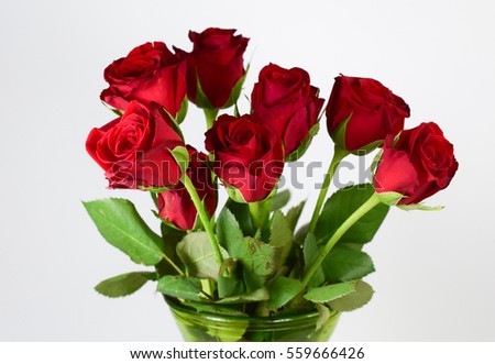 A bouquet of roses in a base on white background.