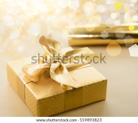 Valentines day gift. Golden box covered with gold foil, ribbon with bow.