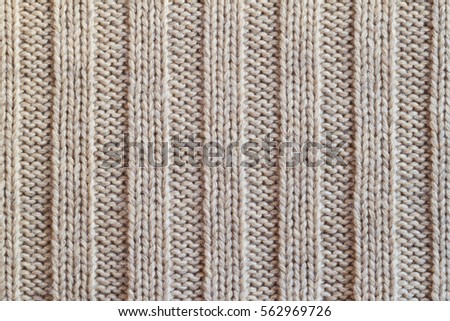 Creamy wool knitted warm clothes for the winter fabric texture background