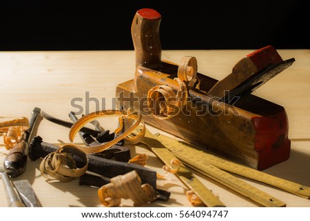 Old woodwork tools: wooden planer, hammer, chisel in a carpentry workshop on wood background
