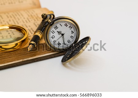 Old book and a pocket watch on a white background.
