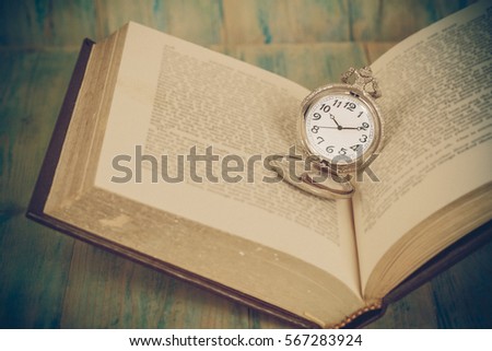Pocket Watch over Age Book Background ,Time 
Concept, Image Tone.