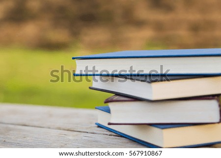 Pile of closed books on wooden background.