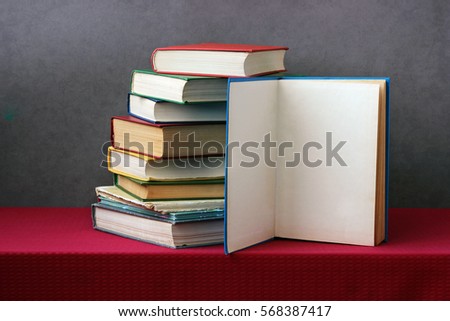 stack of books on the table, one book opened to a blank page (place for text). education, learning, back to school.