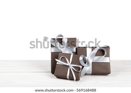 Group of gift boxes wrapped with paper and silver satin ribbon on wood isolated on white background. Modern presents for any holiday, christmas, valentine or birthday
