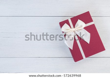 Top view color gift box with ribbon on white wooden plank background