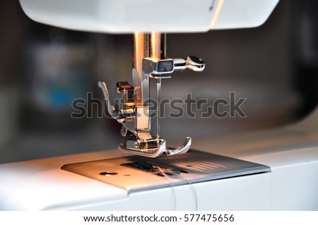 closeup view of electric sewing machine's foot with needle