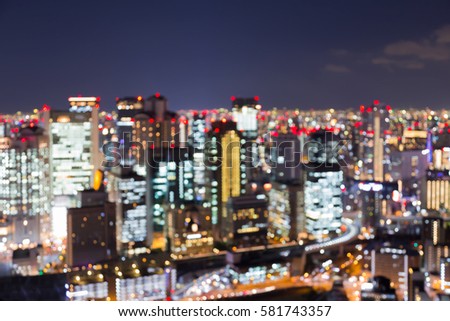 Night blurred lights Osaka business downtown skyline at twilight, abstract background