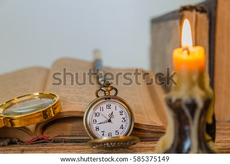 Old book candle on a wooden background