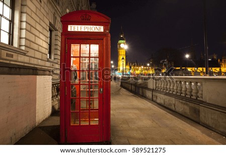 Popular tourist Big Ben and Houses of Parliament with red phone booth in night lights illumination