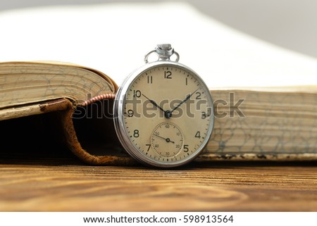 Old pocket watch near old book