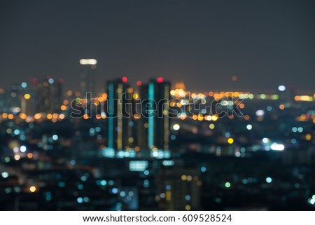 Defocused modern cityscape at night light background, blur urban skyscraper landscape twilight