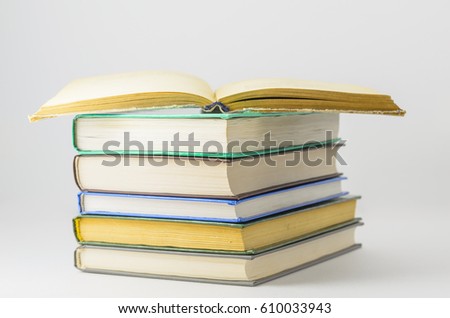 Many closed books lying on a white background.One open book. Horizontal.