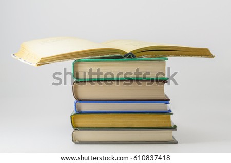 Many closed books lying on a white background.One open book. Horizontal.