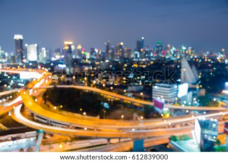 Aerial view city downtown and interchanged overpass blurred bokeh light night view, abstract background
