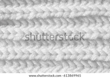 Woolen texture of a knitted product. Hand-made knitting with white knitting needles. Background for a greeting card for Easter.