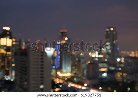 Defocused modern cityscape at night light background, blur urban skyscraper landscape twilight