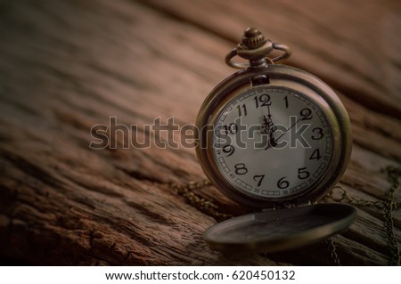 Retro pocket watch on old wooden background
