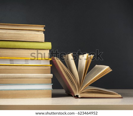 Stack of books on wooden table on black background.Education concept. Back to school.