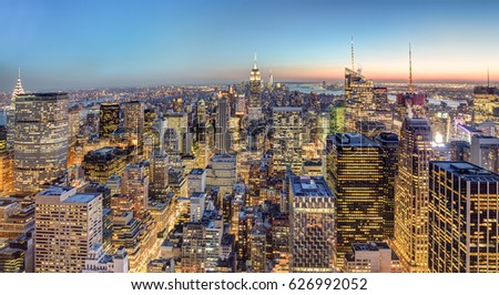 New York City. Manhattan downtown skyline with illuminated Empire State Building and skyscrapers at dusk.
