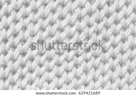 Texture of white wool. Knitting with acrylic knitting needles.