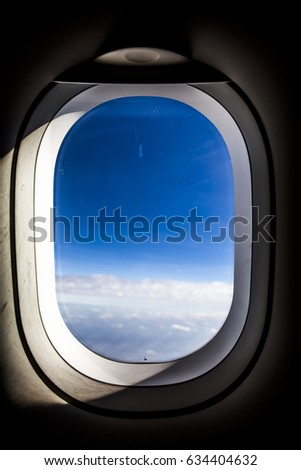 Airplane window with blue sky