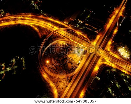 aerial Top view of the junction intercity road at the night with golden light from street lamp