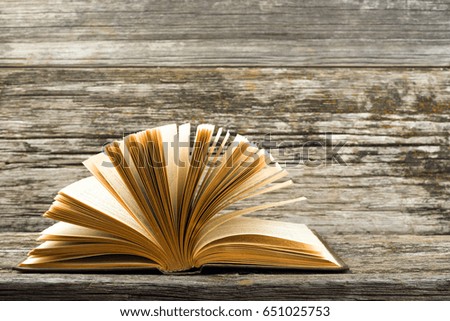 Open old book on a wooden background. 