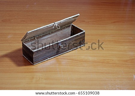 square box made with natural material on wooden background