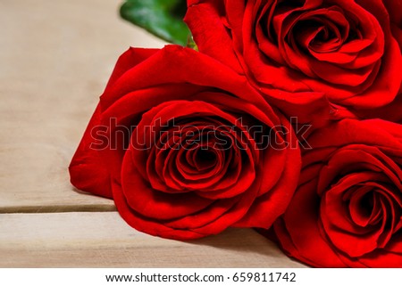 Red roses lying on a wooden table
