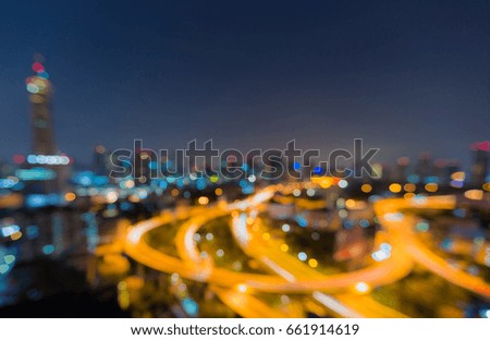 Aerial view city highway intersection and city downtown skyline blurred bokeh light night view, abstract background