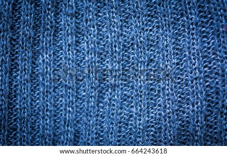 Texture of woolen material. Rectangular background with a blue knitted pattern.