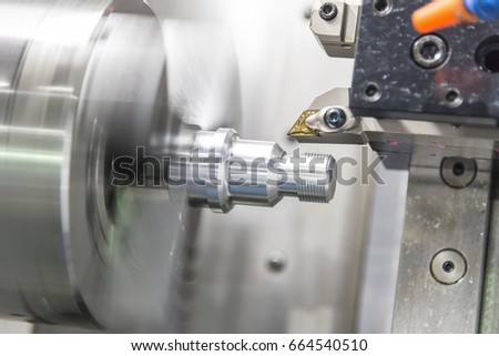CNC lathe machine (Turning machine)  cutting the aluminium screw thread shaft.Hi-precision CNC machining concept.