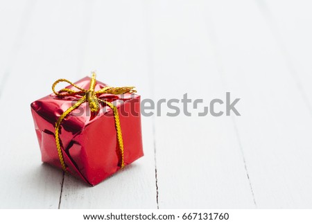 little red gift box on white wood table background
