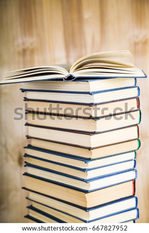 Stack of books on a wooden background. Stack of books with an open book on top of a close-up