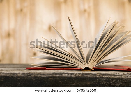 Open book on a wooden table on a brown background.