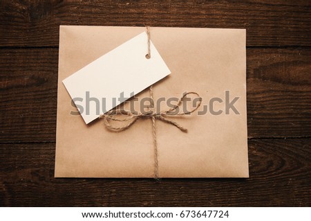 Note from a paper on a cord of an envelope from kraft paper on a wooden table