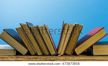 Books on an old wooden table. Beautifu bluel background.