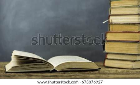 Books on an old wooden table. Beautiful dark background.
