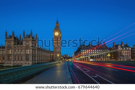 London, England - The famous Big Ben and Houses of Parliament with lights of double decker buses taken on Westminster Bridge at dawn