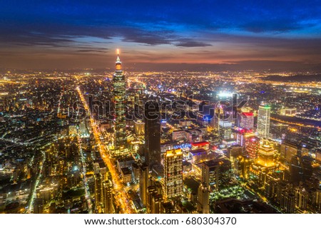 Aerial panorama over Downtown Taipei at night, capital city of Taiwan with view of prominent Taipei 101 Tower amid skyscrapers in Xinyi Financial District 