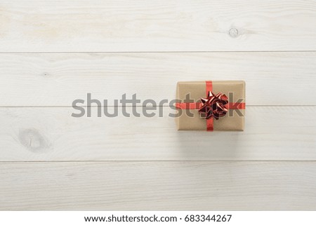 Gift box on wooden white background, view from above
