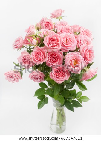 bouquet of pink roses in glass vase on white