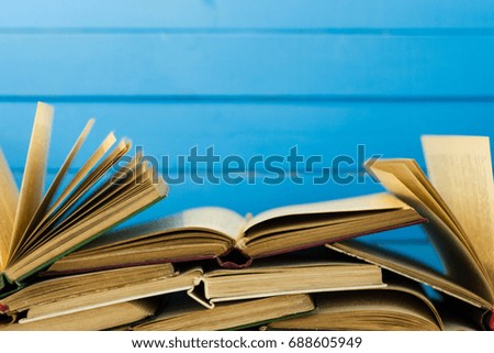 Open book on an white wooden table. Beautiful blue background.