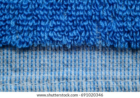 Macro shot of a blue towel. Texture is similar to the texture of a fleecy knotted-pile carpet. Geometric pattern of villi on fabric material. Towels edge finishing element