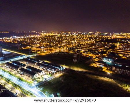 Aerial with blurred view of residential houses in night light.