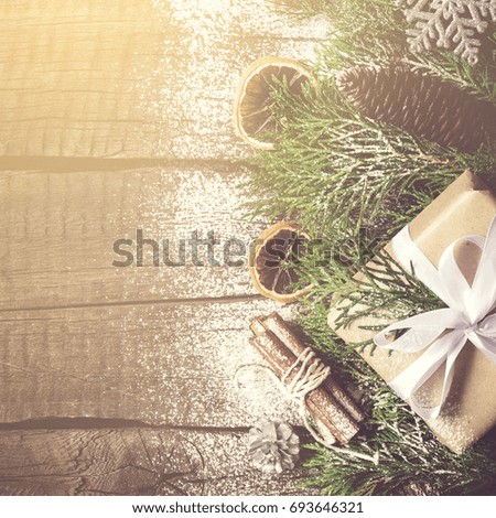 Christmas background and decorated gift, coniferous branches and cinnamon. Toned, copy space