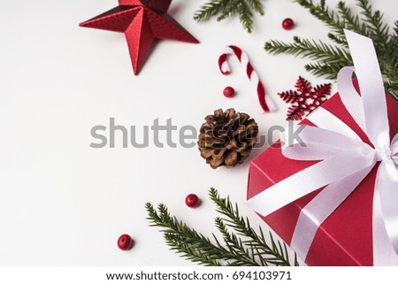 Christmas and New year decoration of gift box and pine leaves and pine cone on white paper background with copy space