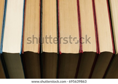 Horizontal row of old thick books close-up